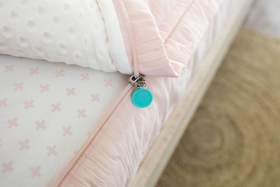 Unzipped pink zipper bedding with white minky lining inside and Beddy's branded zipper pull tab