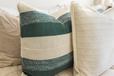 Tan zipper bedding styled with white, tan, cream and green pillows