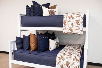 Dark blue zipper bedding on bunk beds with matching blue pillows. Styled with brown and cowboy pillows and blankets
