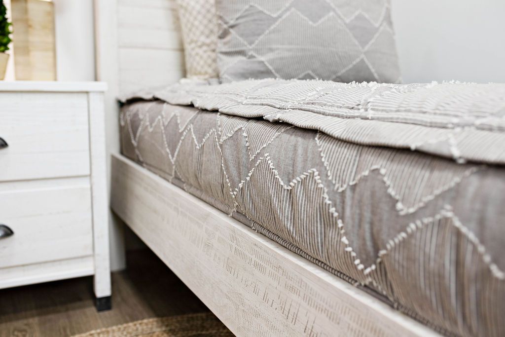 side of twin bed with taupe bedding with textured zig zag design