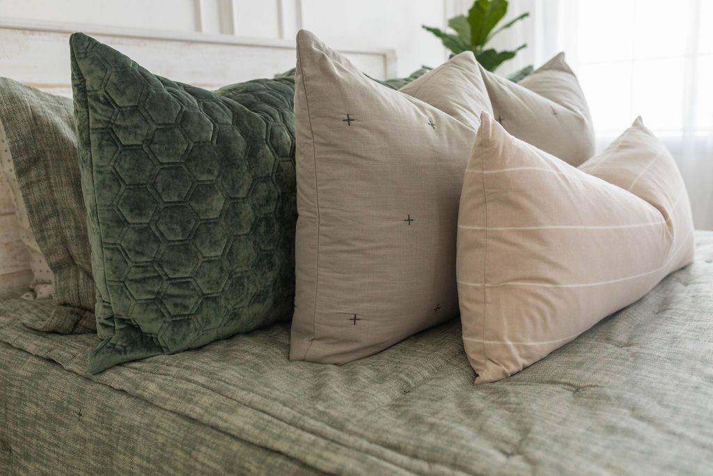 Green zipper bedding with matching pillows, green velvet hexagon pattern pillow, and cream lumbar pillow 