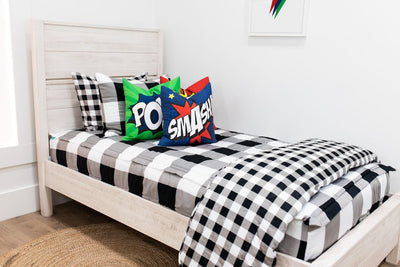 Black and white checker zipper bedding and blanket styled with matching and comic book pillows