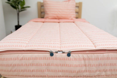 The foot of a bed made with pink ballet shoes kids zipper bedding showing where the two zippers are located.