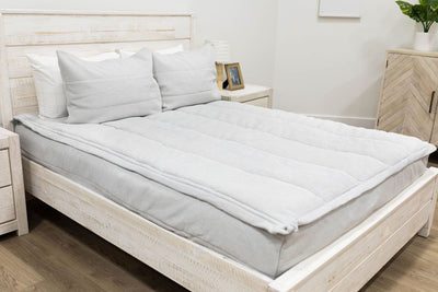 A bed made with light gray waffle textured zipper bedding and matching pillows.