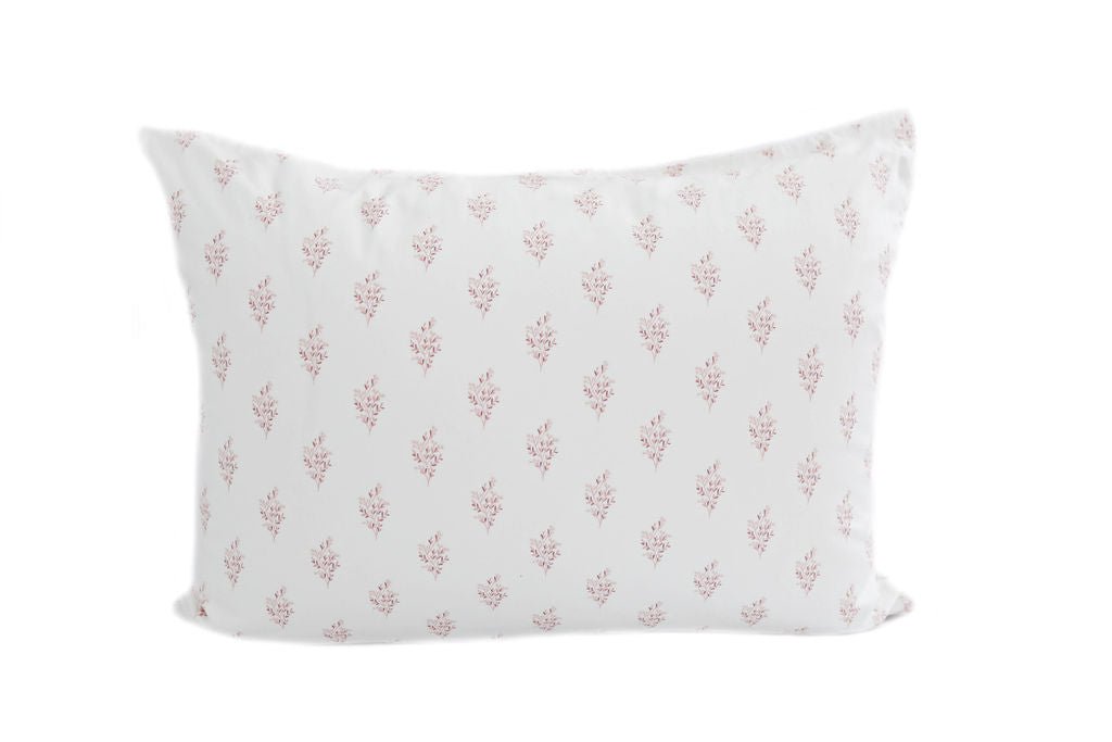 A white pillowcase with a pink flower pattern design. 