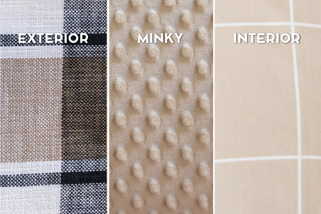 A close up view of a bed made with charcoal, cream and tan plaid zipper bedding.