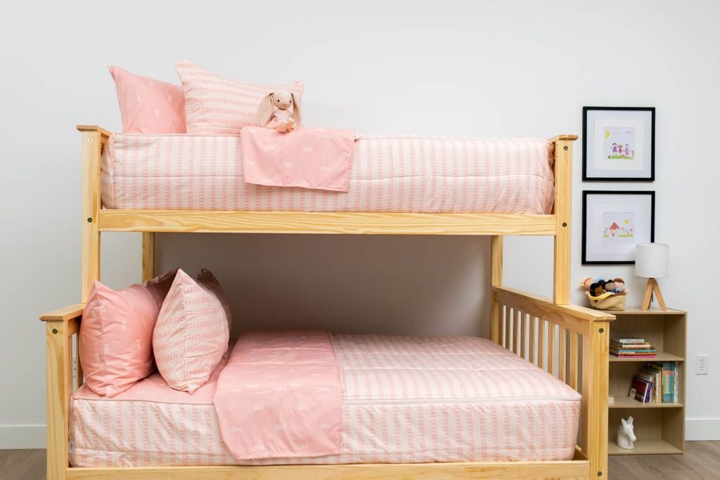 A bunk bed where both bunks are made with pink ballet shoes kids zipper bedding.