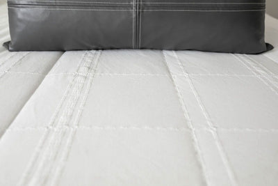A close up of the woven plaid detail on white zipper bedding.