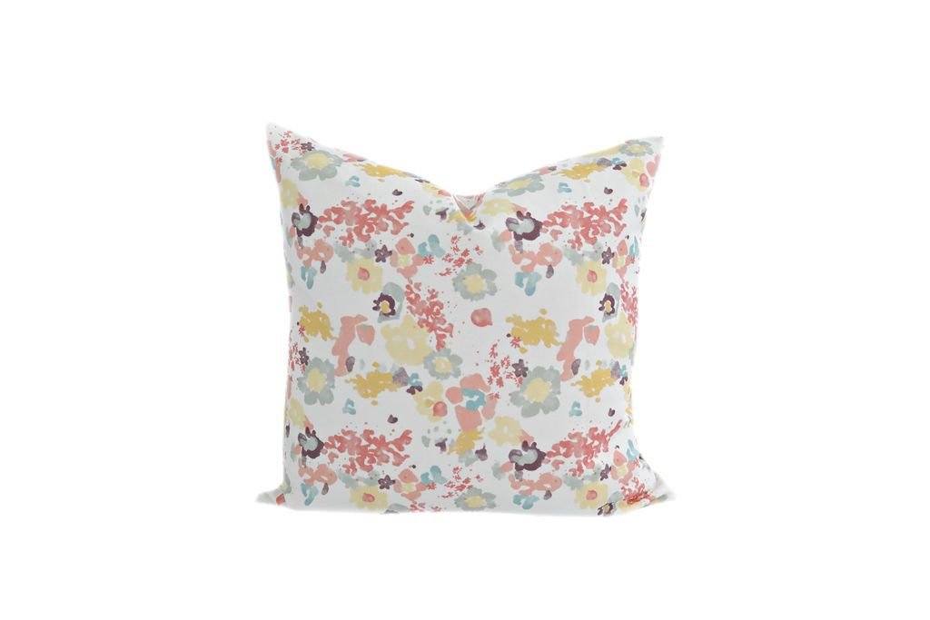 A multi-colored watercolor floral pattern pillow on a white background.