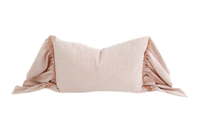 A pink lumbar ruffled pillow with lace details.