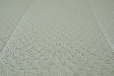 A close up detailed view of the honeycomb texture on sage green zipper bedding.