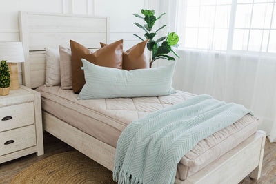 twin bed with Tan textured zipper bedding, faux leather euro pillows, sage green extra long lumbar pillow and sage green chenille textured throw