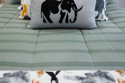 Green striped bedding with white and black grid patterned euro, safari animal print pillow, gray lumbar with embroidered elephant and safari animal print blanket