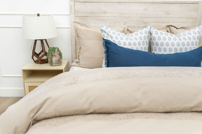Tan duvet bedding styled with tan, blue and white pillows
