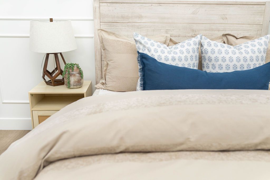 Tan duvet bedding styled with tan white and blue decorative pillows