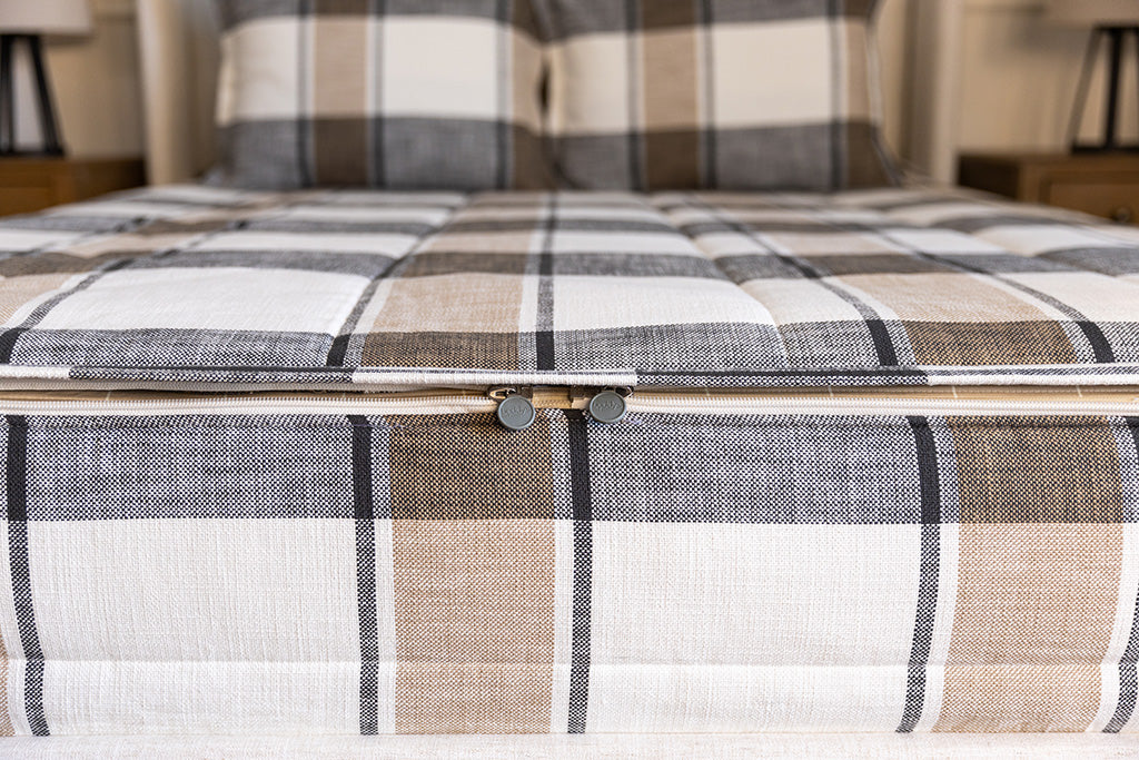 A close up view of the charcoal, cream and tan plaid design on the zipper bedding.