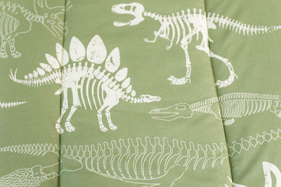 A close up of the print on a set of olive green dinosaur fossils kids zipper bedding.
