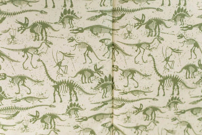 A close up of the interior of a set of olive green dinosaur fossils zipper bedding.