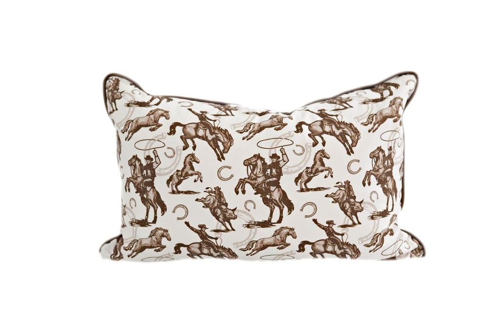 White lumbar pillow with cowboy and horseshoe pattern design