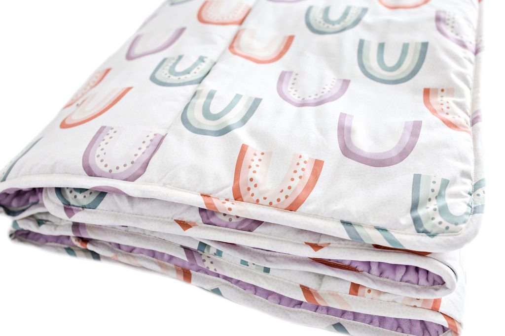 White blanket with purple, green and orange ombre rainbows