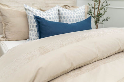 Tan duvet bedding on bed with matching accessories 