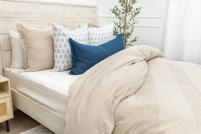 Tan duvet bedding on bed with matching accessories 