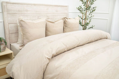 Tan duvet bedding on bed with matching accessories 