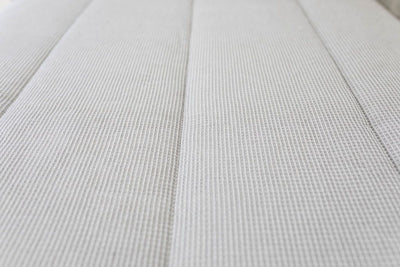 A close up of the waffle textured detail on light gray zipper bedding.