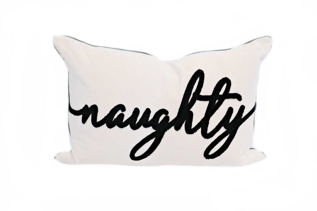 White pillow with black text spelling 'naughty'