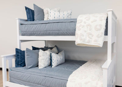 Bunk bed with Light blue zipper bedding with matching sham and dark blue pillow case. Decorated with white pillows and white blanket