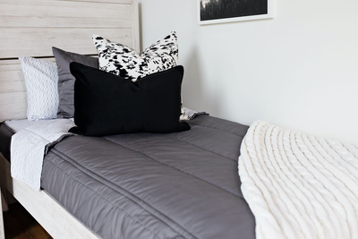 gray zipper bedding with cowhide euro, plush black lumbar and cream knitted chenille throw