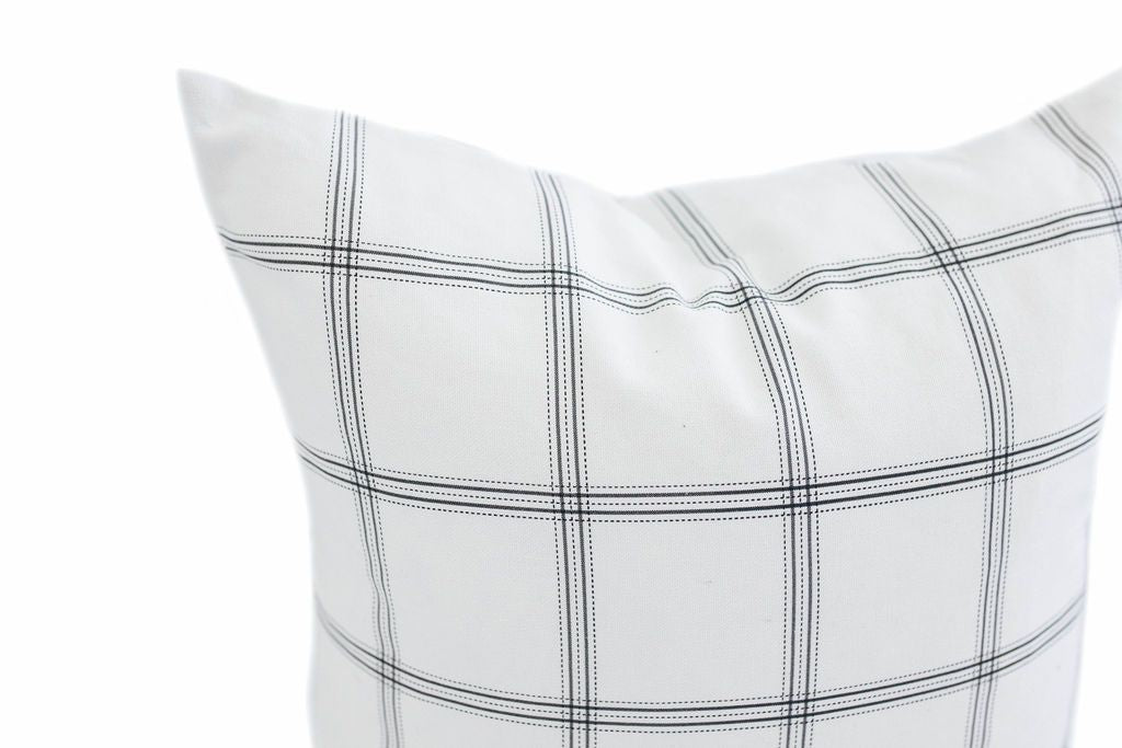 corner of white pillow with dark gray plaid print