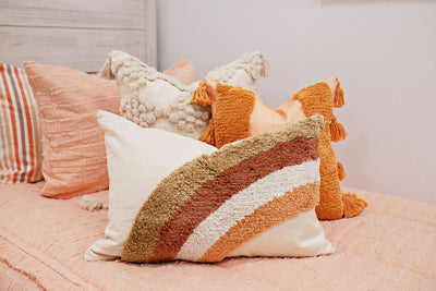 Enlarged view of peach textured bedding, a cream textured euro pillow, a medium peach textured pillow and a boho rainbow lumbar pillow.