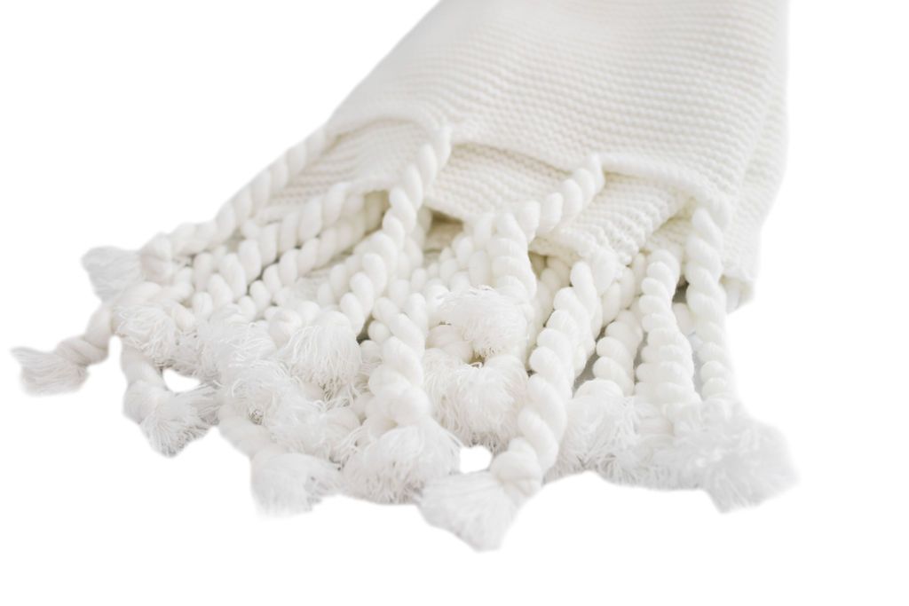 white knitted blanket with braided tassels
