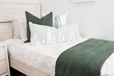 twin bed with White bedding with texturized diamond design with moss green corduroy euro, white euro with moss green lines, white XL lumbar with moss green stitching and moss green knitted chenille throw with tassels
