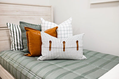 Green striped bedding with white and black grid euro, faux leather pillows, white and black striped lumbar with faux lather buckles 
