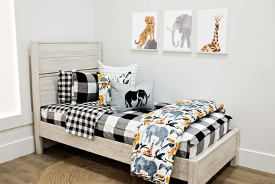 twin bed with black and white buffalo plaid bedding with white and black grid patterned euro, safari animal print pillow, gray lumbar with embroidered elephant and safari animal print blanket