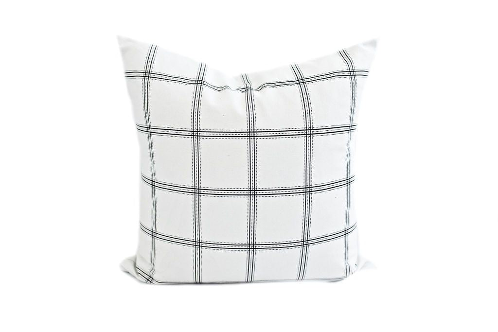 white pillow with dark gray plaid print