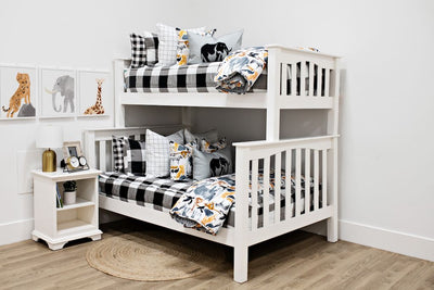 White bunk beds with black and white buffalo checked bedding, white and black grid pillows, jungle animal pillows, a gray lumbar pillow with an elephant and a blanket with jungle animals.  