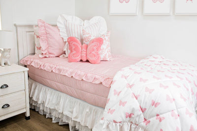 White twin bed with a pink and white striped ruffled bedding, a white and pink striped pillow, a white and pink butterfly pillow, a pink butterfly shaped pillow and a white and pink butterfly blanket.  