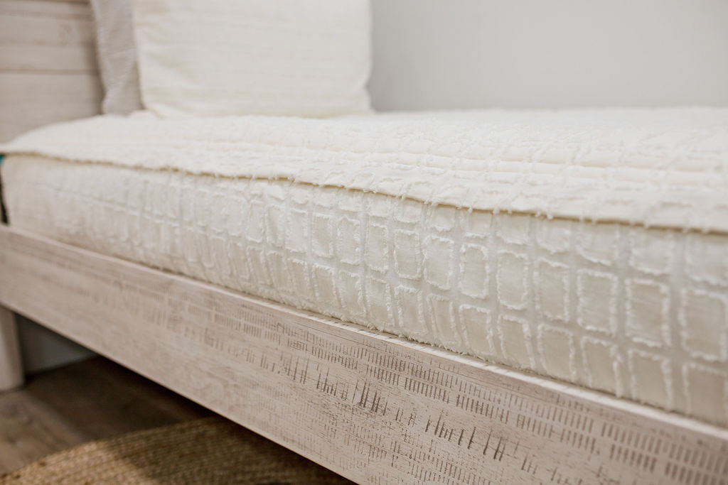 side of Twin bed with cream bedding with textured rectangle design