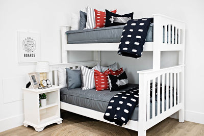 bunk bed with gray zipper bedding and White and black striped euro, red and white dashed pillow, black lumbar with white longboard print, black blanket with white dashed lines at the foot of the bed