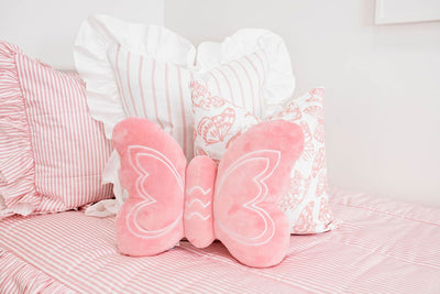 Enlarged view of pink and white striped ruffled bedding, a white and pink striped pillow, a white and pink butterfly pillow, and a pink butterfly shaped pillow.  