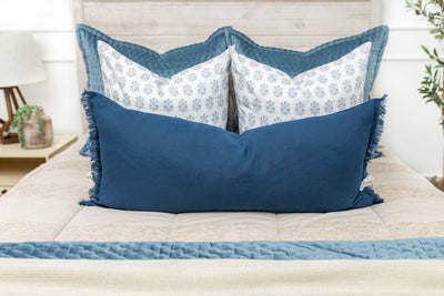 Tan zipper bedding with blue, tan and white pillows and blue and tan blankets