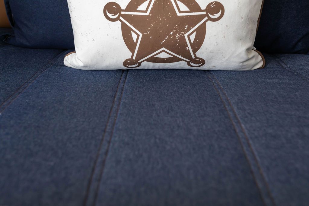 Close up view of Dark blue zipper bedding with cowboy sheriff graphic pillow