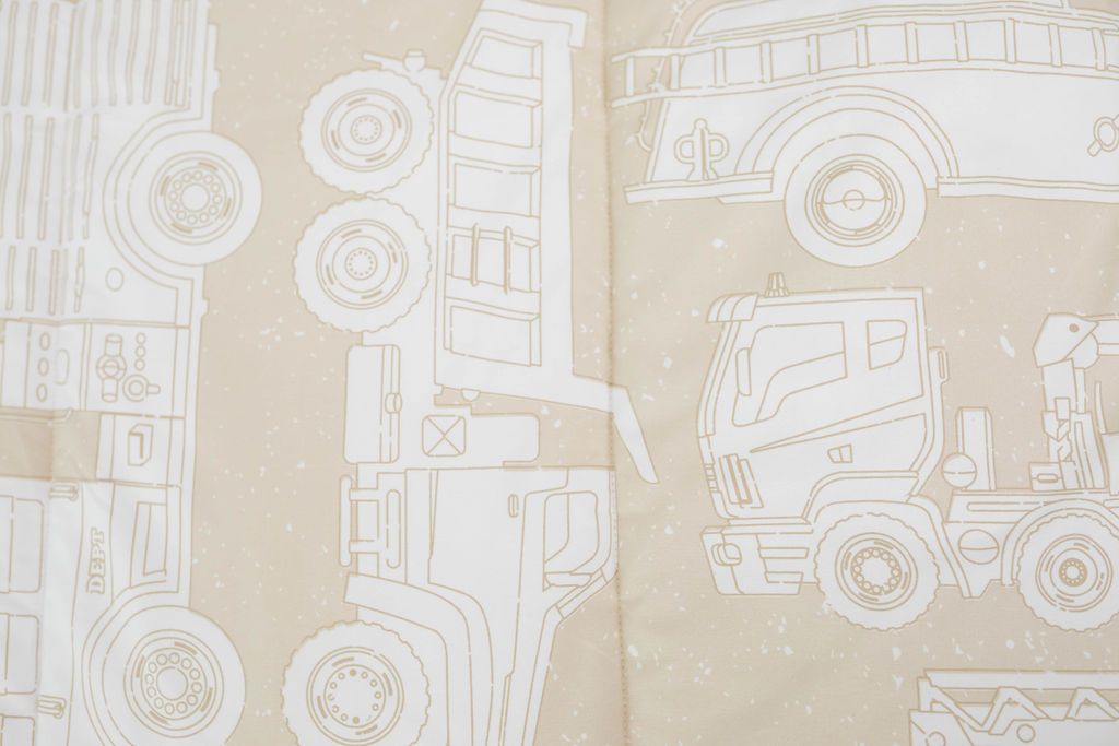 A close up of the print on a set of light tan cars kids zipper bedding.