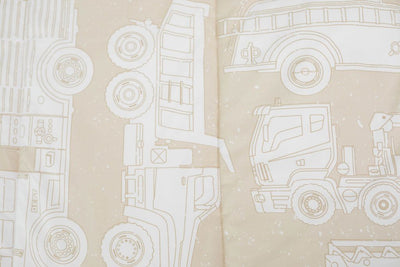 A close up of the print on a set of light tan cars kids zipper bedding.