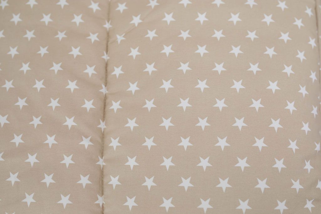 A close up of the interior of a set of light tan cars kids zipper bedding.