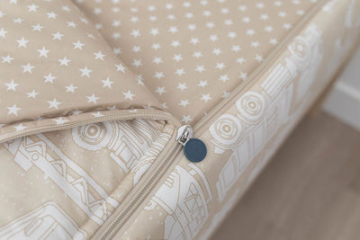 A close up on the zipper feature of a set of light tan cars kids zipper bedding.