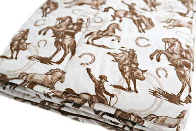 A folded cowboy on a horse with horseshoes in the background printed brown and white pattern blanket.